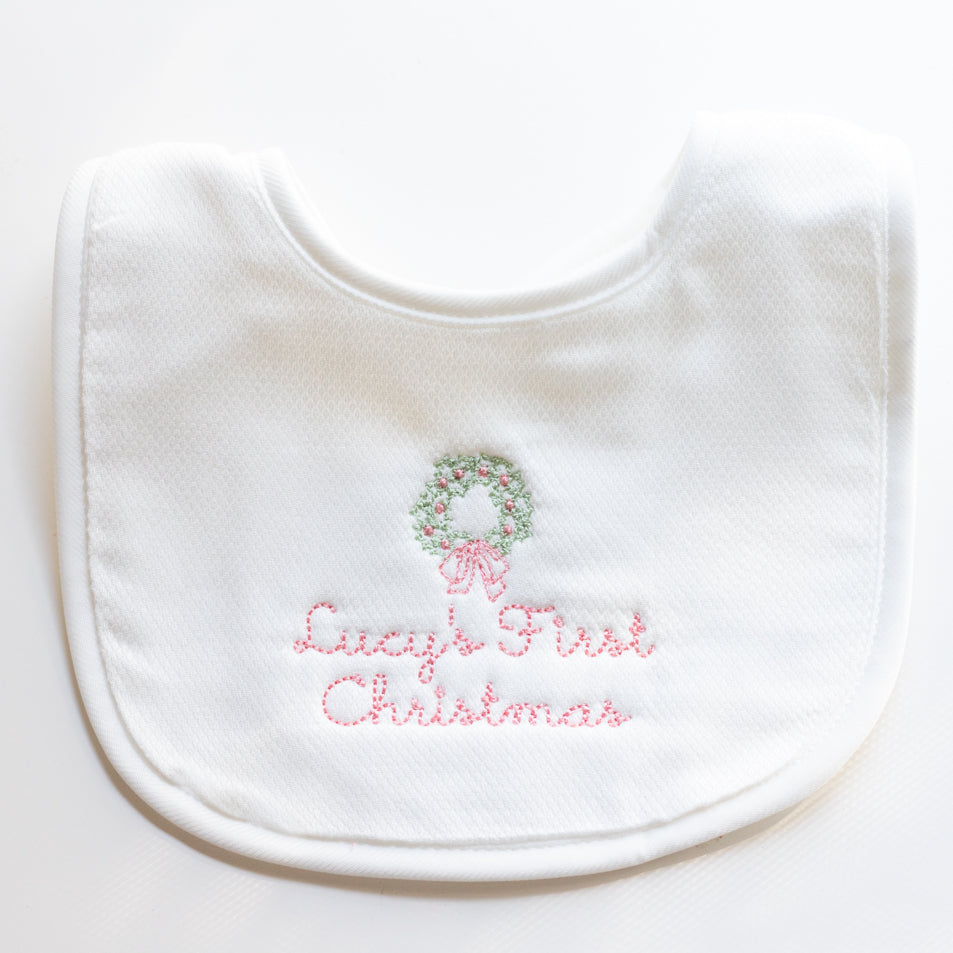 Personalized baby’s first Christmas bib with embroidered name and wreath