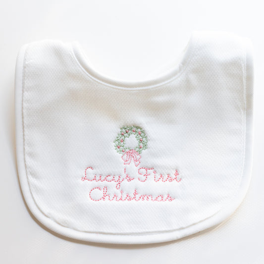 Personalized baby’s first Christmas bib with embroidered name and wreath